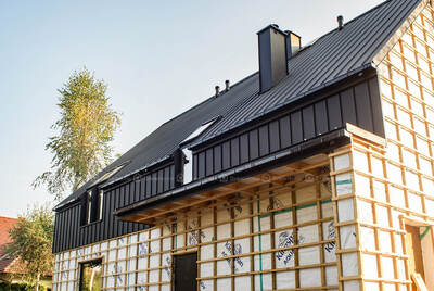 Blacha na elewacji jako przedłużenie dachu na domu szkieletowym w Sośnicowicach koło Gliwic