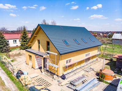 Montaż płyt poszycia na konstrukcji domu w Jasieniu koło Brzeska